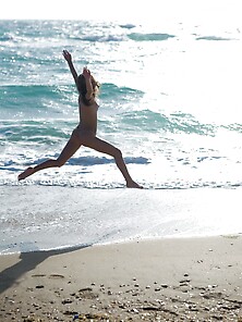 Playful Beach Dweller Shows Off Her Young Nude Body By The Water